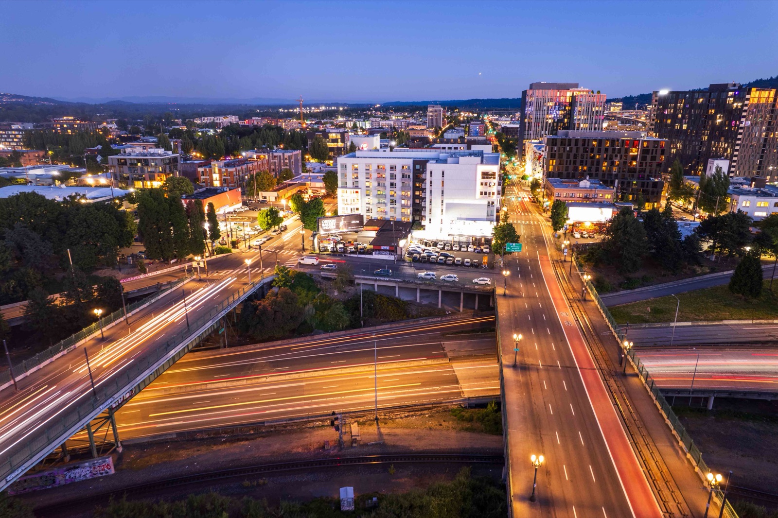 Aerial cityscape with freeway light trails at dusk